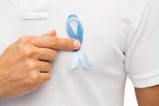 Man holding blue ribbing to his shirt